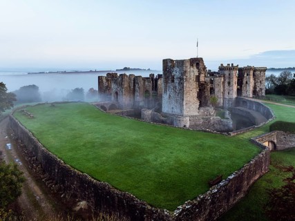 Raglan Castle in the fog at dawn from a drone, Monmouthshire, Wales, England, United Kingdom,
