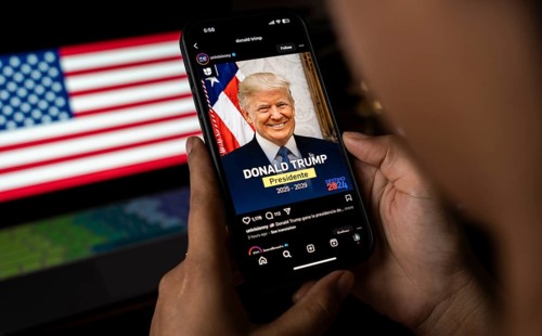 In this photo illustration, a person looks Donald Trump image on a smartphone after results of U.S.