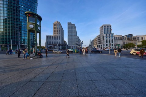 Monument and replica of a historic traffic light system with modern office buildings on Potsdamer