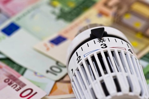 Symbolic photo energy costs, thermostat of a heating system lies on euro banknotes, rising energy