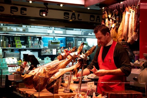 Barcelona, Spain, January 26 2019: Bucher at a meat farmer market counter. Various meat slices at a