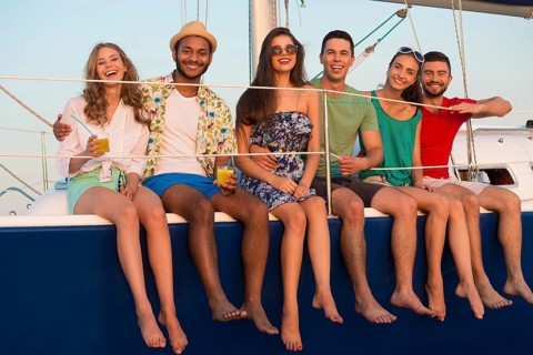 Loving couples relaxing on a yacht. Happy young people sailing on the yacht. Beautiful guys and