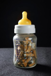 Nicotine tobacco addiction still baby bottle and used cigarettes