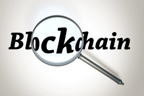 3D illustration of a magnifying glass and the word Blockchain