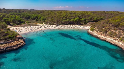Aerial view capturing tourists enjoying the crystal clear turquoise waters at cala s'amarador and