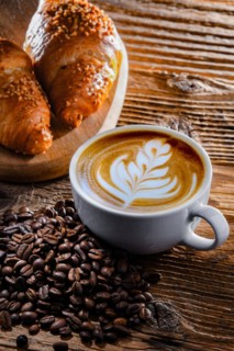 Composition with a cup of coffee and two croissants on an old wooden table