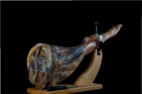 Spanish acorn-fed iberian ham close-up on black background and copy space