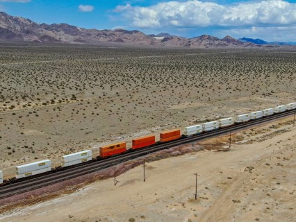 Cargo locomotive railroad engine crossing Arizona desert wilderness. Freight train passing by the