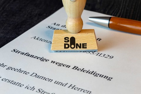 Stamp with the SO DONE logo on a symbolic criminal complaint (Composing) . SO DONE is a reporting