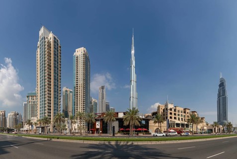 A picture of the Burj Khalifa towering nearby Downtown Dubai buildings