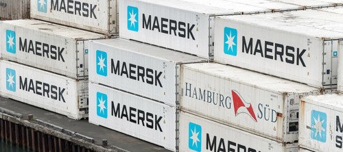 Large group of sea cargo freight containers Maersk and Hamburg Süd stacked on pier in container