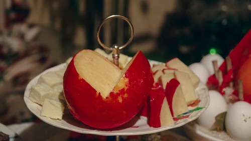 A plate featuring sliced red queso de bola a semi-hard, ball-shaped cheese that's a staple in