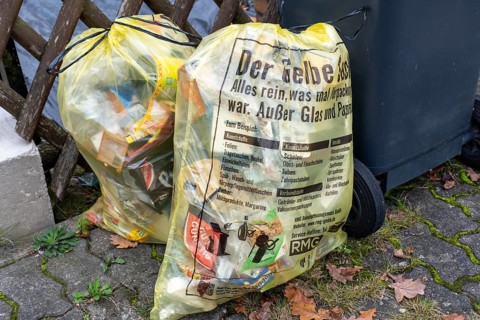Yellow waste bags for plastic recycling and packaging next to waste bins, Garbsen-Stelingen, Lower