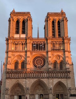 The facade of Notre Dame Cathedral glowing in the warm light of sunset. Paris, France, Europe