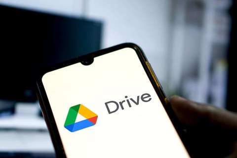 Man holding a smartphone with Google Drive cloud storage app on smartphone.