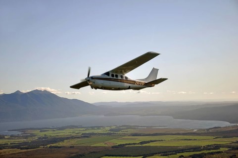 Cessna 210 light aircraft flying over Lake Brunner, Westland, New Zealand, Oceania