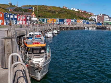Small fishing boats moored on the shore in the inland harbour and in the background