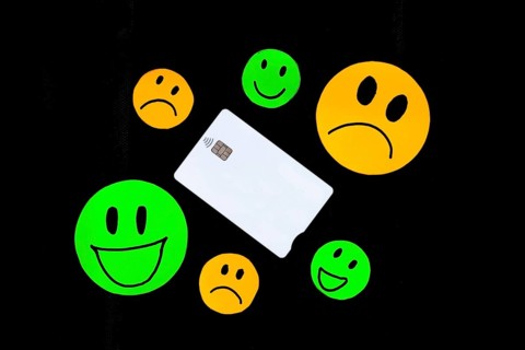 A white plastic card with a chip with contactless payment technology with some drawings of smiling