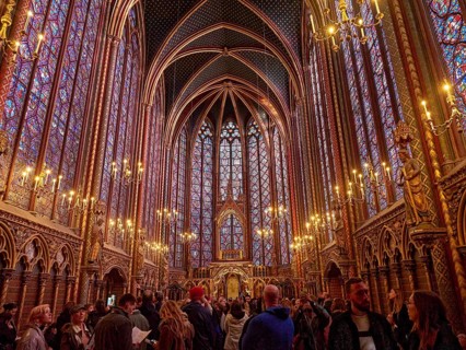 A lively church interior with Gothic architecture and magnificent stained-glass windows,