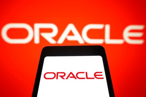 In this photo illustration, the Oracle Corporation logo is displayed on a smartphone screen and in