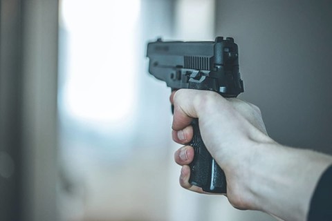 Man is holding a black fire weapon, closeup