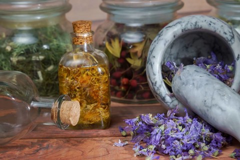 Crushing medicinal plants in a mortar and pestle with different homeopathic preparations in the