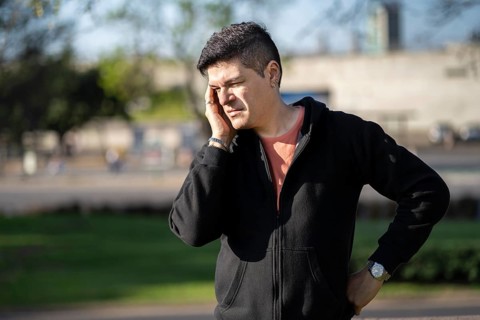 Stressed and tired man touches his head because of a headache
