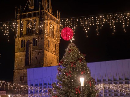 Large Christmas tree in front of illuminated church at night, festive atmosphere, ahaus,