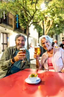 Vertical photo of a senior couple enjoying tapas and beer in the city of Madrid, Spain, Europe