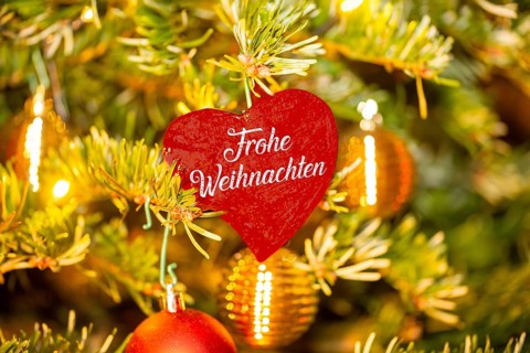 Christmas greetings: Heart with the inscription FROHE WEIHNACHTEN on a Christmas tree