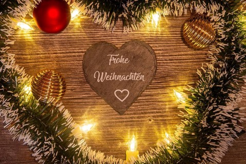 Christmas greetings: Heart with the inscription FROHE WEIHNACHTEN with Christmas decorations