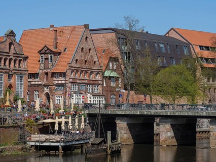Charming half-timbered houses flank a river, while a bridge leads to a historic neighbourhood,