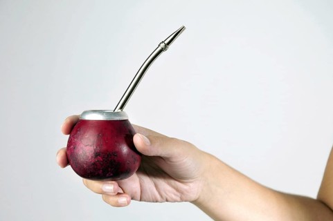 Hand and Yerba Mate drink on white background