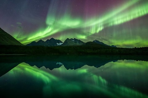 Northern lights over the mountains of the Lyngen Alps, reflection in lake, Lyngen, Norway, Europe