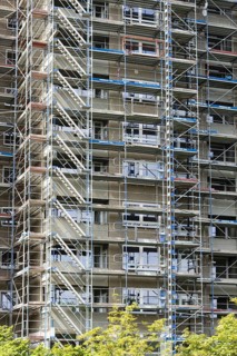 Scaffolded high-rise residential building with balconies and satellite dishes, Trabantenstadt