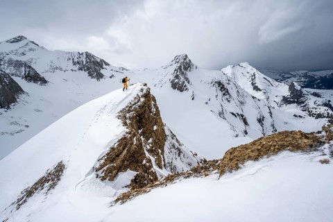 Ski tourers climbing the Niesehorn, Wildhorn summit behind, snow-covered mountain landscape,