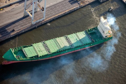 Aerial view of a cargo ship in the port of Hamburg with a lot of exhaust gas, emissions, smoke,