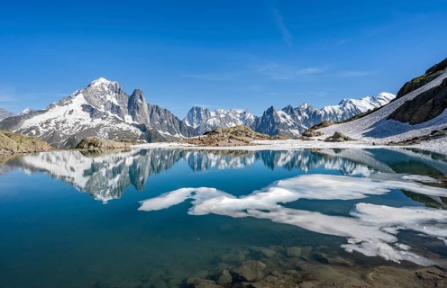 Mountain landscape with mountain lake and ice floe, water reflection in Lac Blanc, mountain peak,