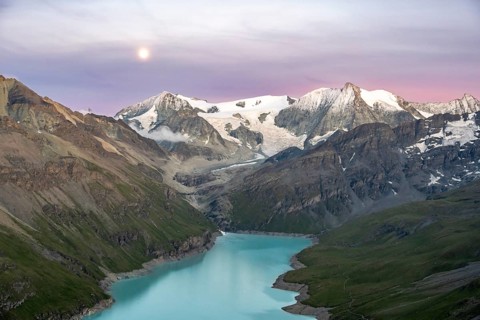 Mountain landscape with turquoise blue reservoir Lac des Dix and summit Mont Blanc de Cheilon, moon