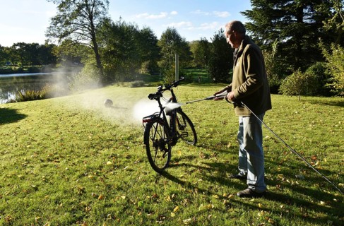Man cleans bicycle with high-pressure cleaner