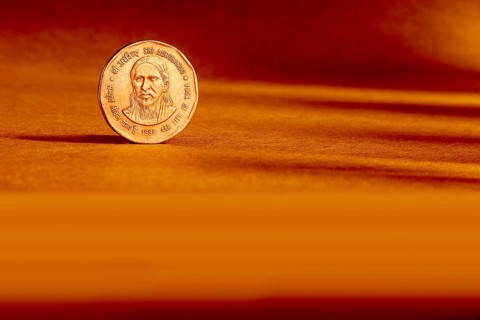 One Indian currency two rupees coin backside embossed Sri Aurbindo all life is yoga 1998 on orange