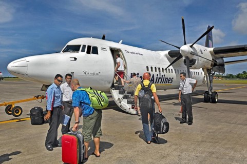 Propeller aircraft, prop jet Fokker 50, former Riau Airlines, passengers and staff at the airport