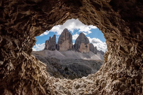 View out of an old tunnel window towards the iconic Three Peaks mountain in the Dolomite Alps,