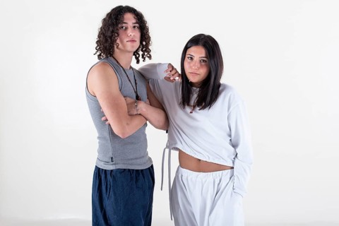 Portrait of a young couple dressed in yoga clothes looking ti the camera white background. Studio