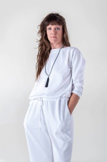 Portrait of a woman dressed in white yoga clothes over white background wearing a japa mala while