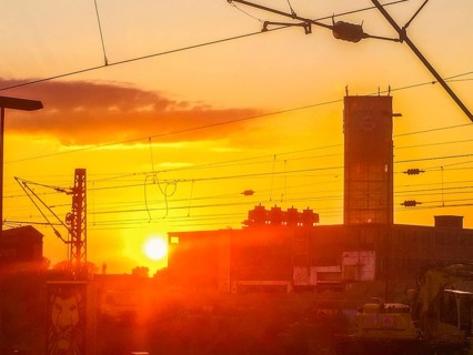 Sunset behind buildings with power lines and orange-coloured sky, Gerresheimer Germany, Lost Place,