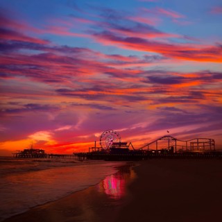 Santa Monica California sunset on Pier Ferrys wheel and reflection on beach wet sand