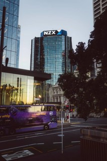 Modern glass building labelled NZX, surrounded by urban environment, new zealand stock exchange,