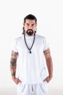 Portrait of a man dressed in white yoga clothes over white background while looking at camera.