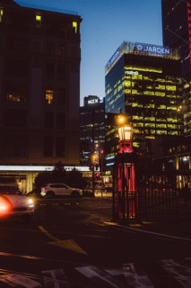 Night city view with illuminated buildings and a passing car, urban lighting, new zealand stock